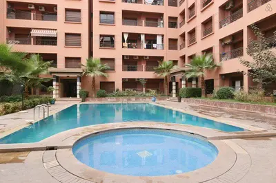 a large swimming pool in front of a building at Palace-Apartment-Marrakech in Marrakech