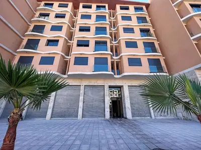 a large building with palm trees in front of it at High-End Cozy and Modern Studio in Marrakech