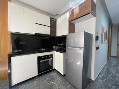 a kitchen with white cabinets and a refrigerator at High-End Cozy and Modern Studio in Marrakech