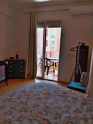 a bedroom with a bed and a view of a table at Appartement calme et spacieux pour famille in Marrakech