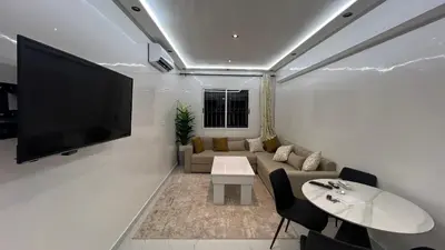 a living room with a couch and a tv on a wall at Stylish & Cozy Apartment in Marrakech in Marrakech