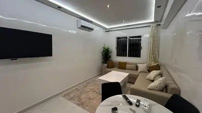 a living room with a couch and a flat screen tv at Stylish & Cozy Apartment in Marrakech in Marrakech