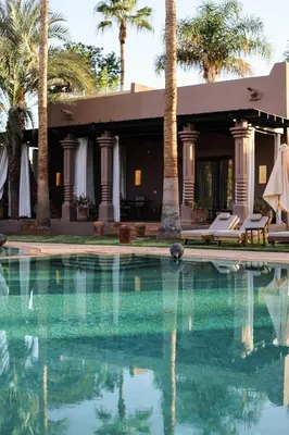 a house with a swimming pool and palm trees at Luxury Resort Loudi Marrakech in Marrakech