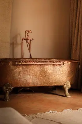 a copper bath tub sitting on top of a wooden floor at Luxury Resort Loudi Marrakech in Marrakech