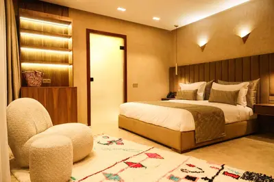a bedroom with a large bed and a chair at Luxury Resort Loudi Marrakech in Marrakech