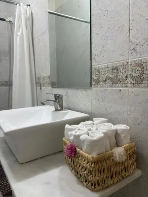 a bathroom with a tub and a sink and towels at BELDI and contemporary elegance in Marrakech