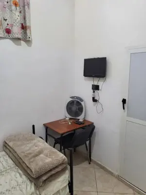 a room with a desk with a bed and a table with a fan at Maison D'hôte Dar ALBIDAWI CH5 in Marrakech