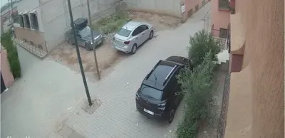 two cars parked on a street next to a parking meter at Maison D'hôte Dar ALBIDAWI CH5 in Marrakech