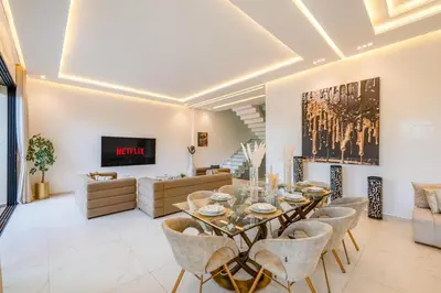 a living room with a dining table and chairs at Villa cancun resort Luxury Spa-cinéma & jacuzzi in Marrakech
