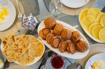 a table topped with plates of food with bread and pastries at Villa cancun resort Luxury Spa-cinéma & jacuzzi in Marrakech