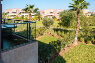a house with a view of a park with palm trees at Elegant Appartement Piscine Golf et Wifi in Marrakech