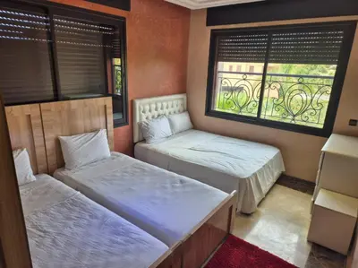 two beds in a room with a window at Comfort and Style in the Heart of the City - Villa T in Marrakech