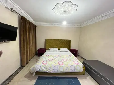 a bedroom with a bed and a flat screen tv at Comfort and Style in the Heart of the City - Villa T in Marrakech