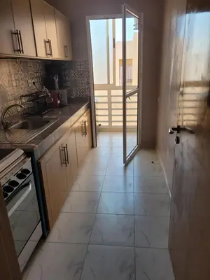 a kitchen with a door open to a kitchen with a tile floor at japoniya in Marrakech