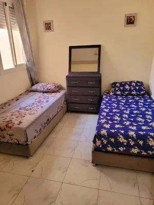 a bedroom with two beds and a dresser and a mirror at japoniya in Marrakech