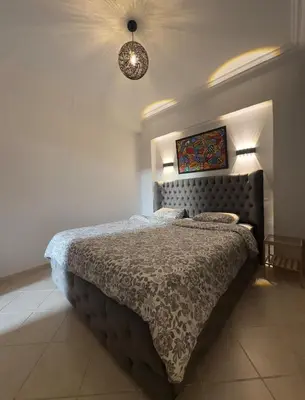 a bedroom with a large bed with a comforter at Elegant Apartment Marrakech in Marrakech