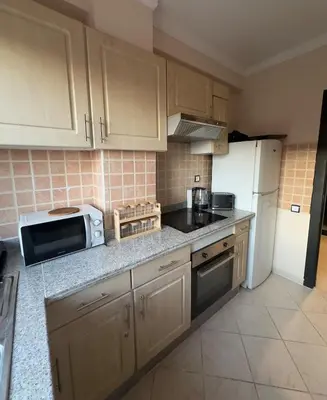 a kitchen with a white refrigerator and a microwave at Elegant Apartment Marrakech in Marrakech