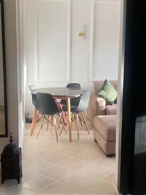 a living room with a table and chairs and a couch at Elegant Apartment Marrakech in Marrakech