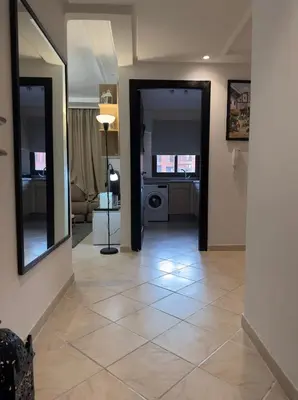 a living room with a tile floor and two mirrors at Elegant Apartment Marrakech in Marrakech