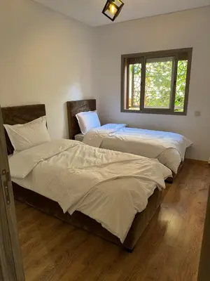 two twin beds in a room with a window at Appartement moderne et chic in Marrakech