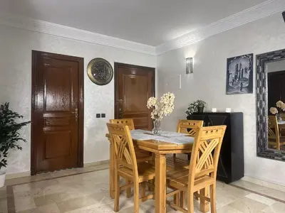 a dining room with a wooden table and chairs at Charmant & chic à Gueliz in Marrakech