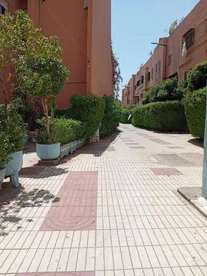 a sidewalk with trees and plants in a building at Mhamid airport in Marrakech