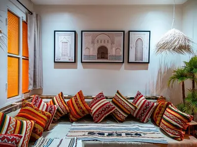 a couch with colorful pillows in a living room at Dar LalaFadma-Pvt 1BR Studio-1min to Bahia Palace in Marrakech