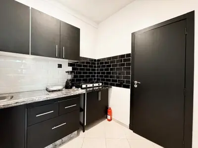 a kitchen with black cabinets and a black door at Budget-Friendly 2BR - AC and heating in All Rooms in Marrakech