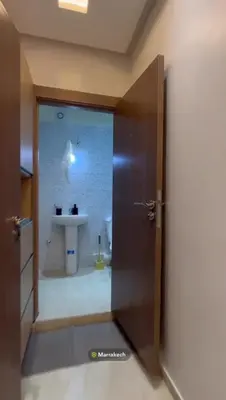 an open door to a bathroom with a sink at Appartement in Marrakech