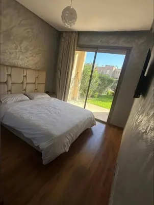 a bedroom with a large bed and a large window at Prestigia Jubaea Marrakech Argane in Marrakech