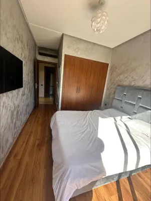 a bedroom with a large white bed and a television at Prestigia Jubaea Marrakech Argane in Marrakech