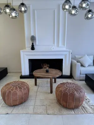 a living room with a coffee table in front of a fireplace at Golf el maaden Splendide villa in Marrakech