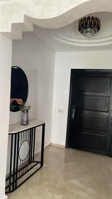 a room with a black door and a table with flowers at VILLA aVEC PISCINE CHAUFFÉE in Marrakech
