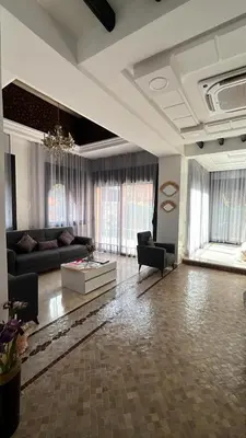 a living room with a couch and a table at VILLA aVEC PISCINE CHAUFFÉE in Marrakech