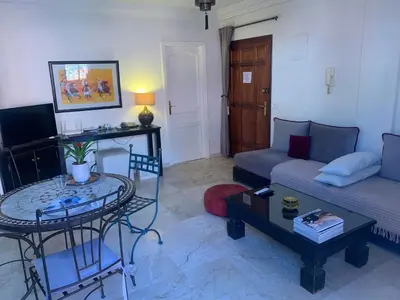a living room with a couch and a table at BEL APPARTEMENT CENTRE MARRAKECH GUELIz in Marrakech