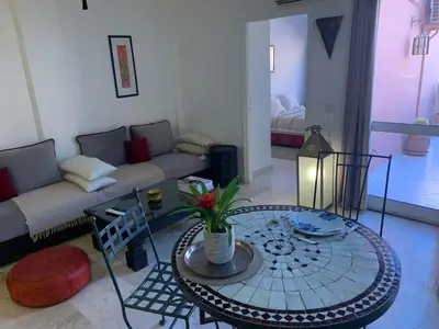 a living room with a table and a couch at BEL APPARTEMENT CENTRE MARRAKECH GUELIz in Marrakech