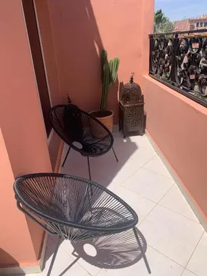 a balcony with two chairs and a cactus at BEL APPARTEMENT CENTRE MARRAKECH GUELIz in Marrakech