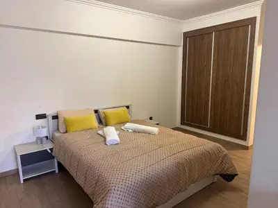 a bedroom with a bed with yellow and white pillows at Appartement avec piscine en plein centre de Marrakech in Marrakech