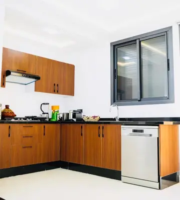 a kitchen with wooden cabinets and a window at Vaste duplex neuf modernes et raffiné in Marrakech