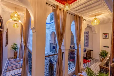 a home with a hallway with curtains and a balcony at Riad La Perle Bleue Marrakech in Marrakech