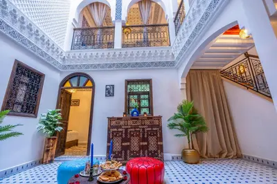 a room with a table and chairs and a ceiling at Riad La Perle Bleue Marrakech in Marrakech