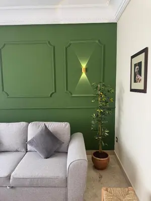 a living room with a couch and a green wall at Cozy flat in Marrakesh in Marrakech