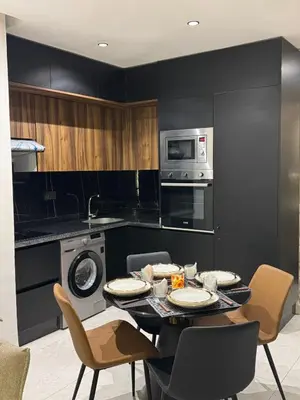 a kitchen with a table with chairs and a microwave at Modern and Cozy Apartment Guéliz in Marrakech