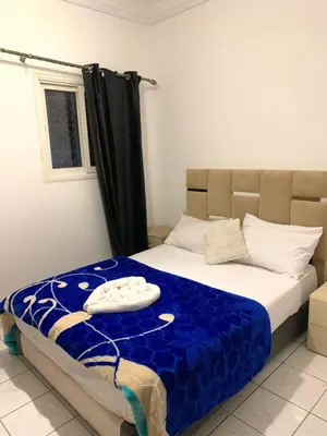 a bedroom with a bed with a blue comforter at Maison majid in Marrakech