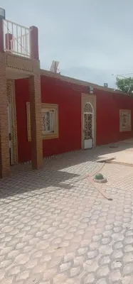 a red building with two doors and a courtyard at nice mini villa with pool in Marrakech