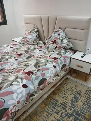 a bed with a flowered comforter in a bedroom at Cosy appartement Victor Hugo in Marrakech