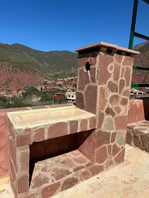 a stone fireplace on top of a building with a view at villa ourika in Marrakech
