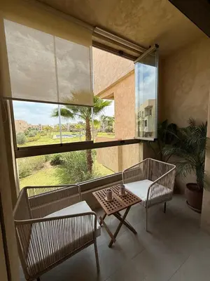 a room with two chairs and a table and a large window at Appartement cosy pour 4 personnes in Marrakech