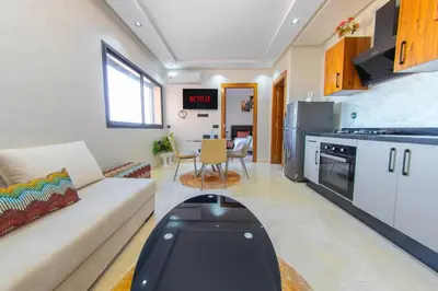 a living room with a couch and a kitchen at New apartment with pool in Marrakech