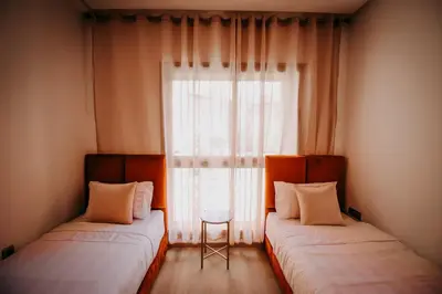 two beds in a room with a window at Spacious 3BR with Prime Location in Marrakech